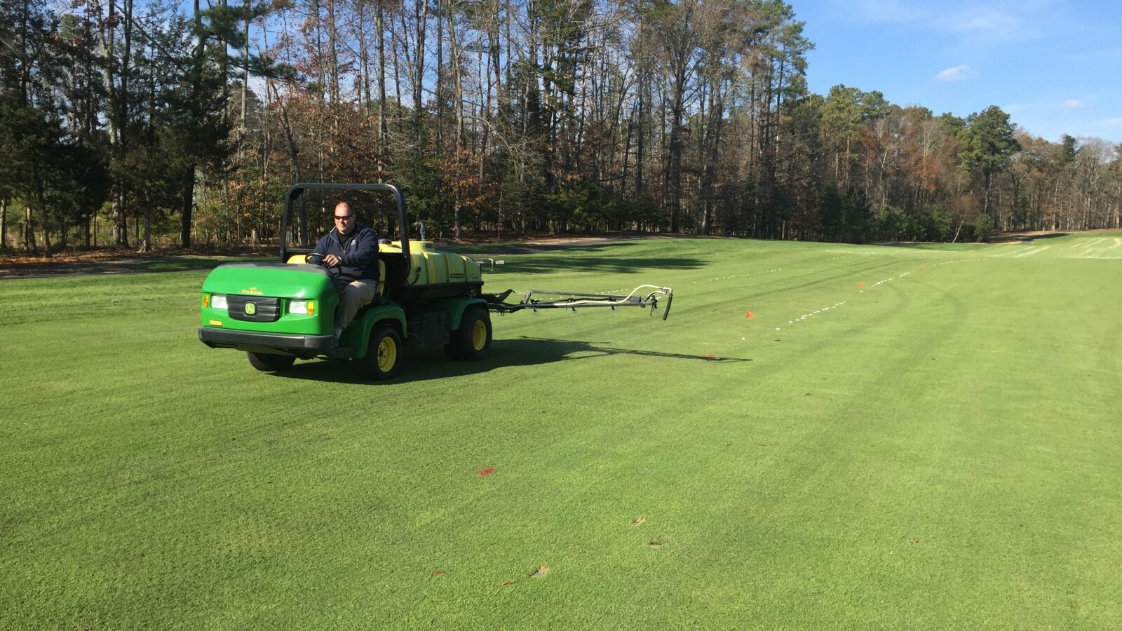 Utility vehicle spraying a golf fairway as part of a soil health program