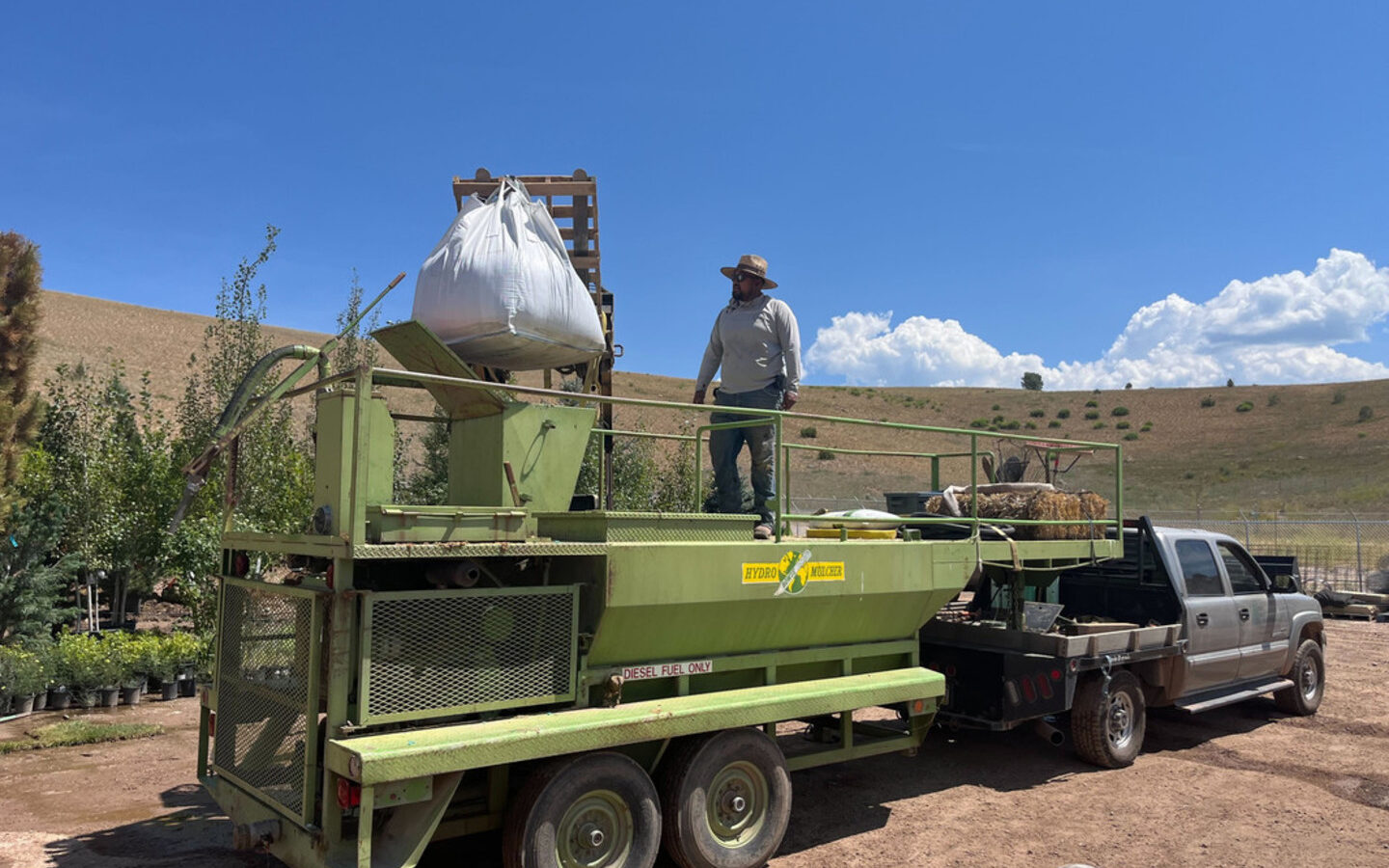 Crew loading a supersack of CarbonizPN onto a spreader trailer