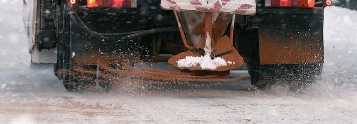 Trucks spreading salt are essential for winter deicing but cause salt damage to lawns and landscapes.